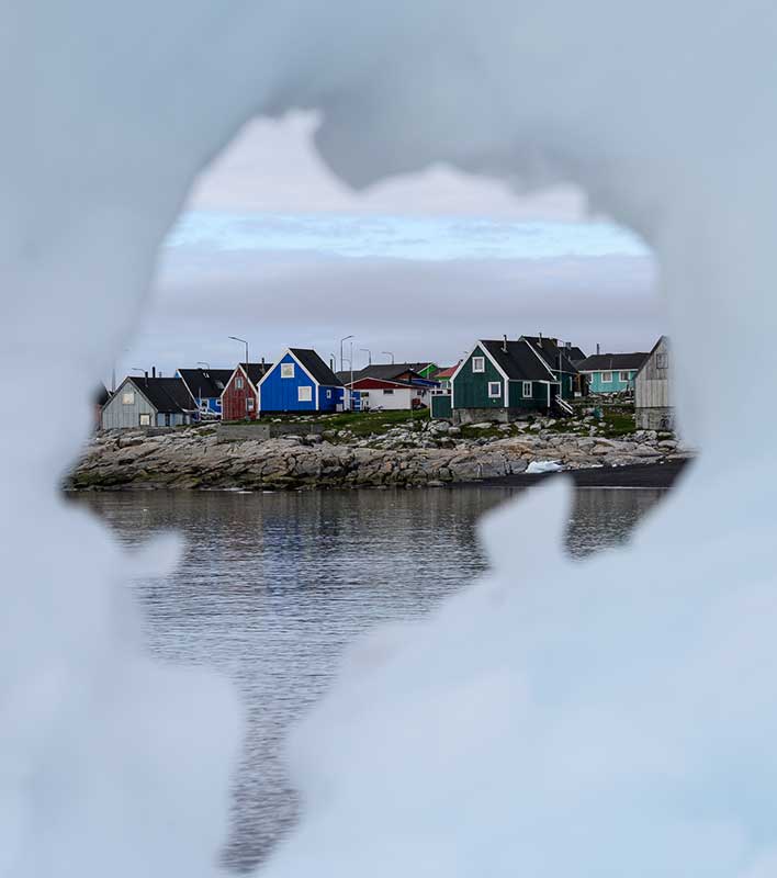 Blick durchs Eis auf ein Dorf in Grönland